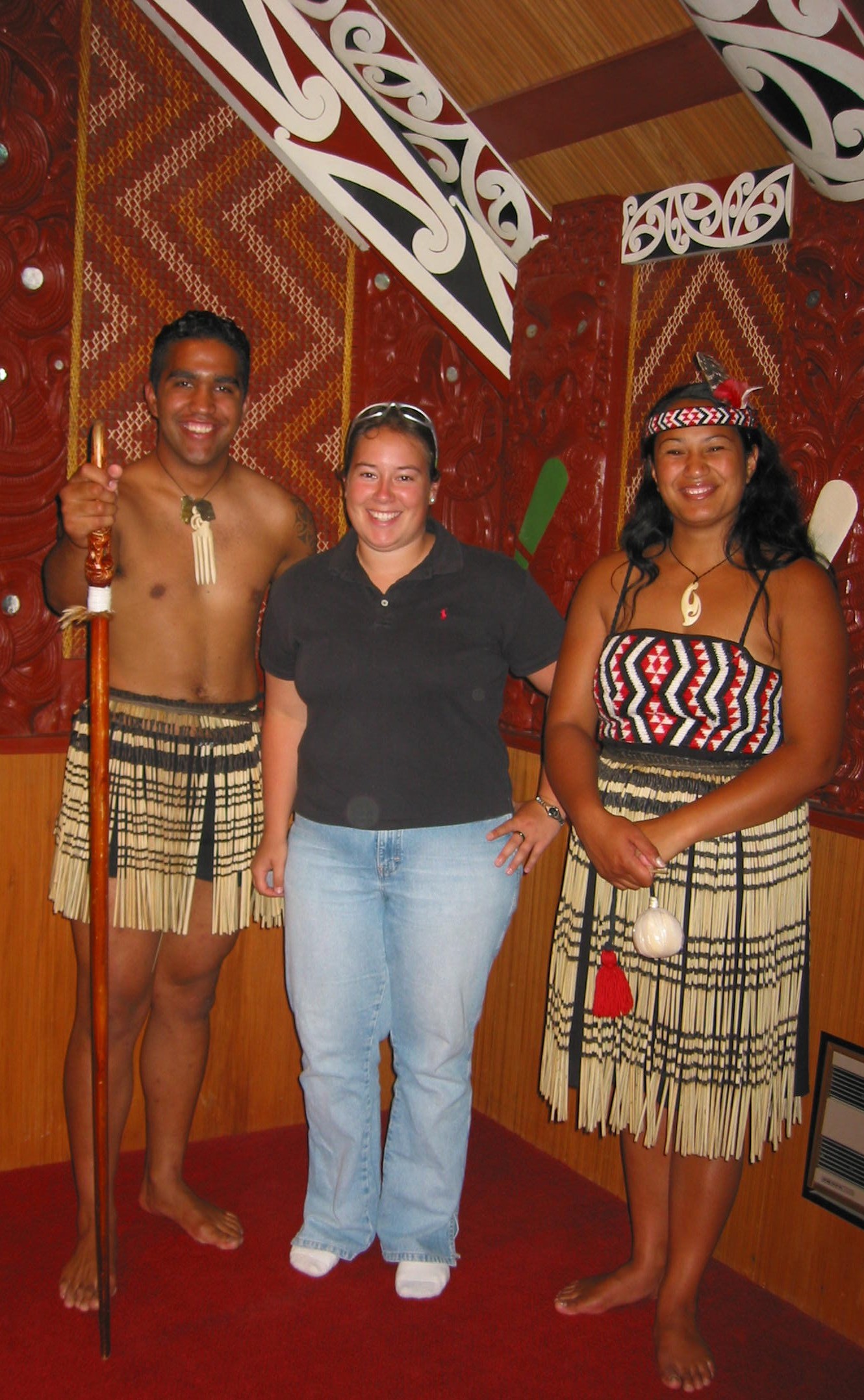 Maori. Two performers of the powhiri group pictured inside the Whakarewarewa Marae with one of the visitors